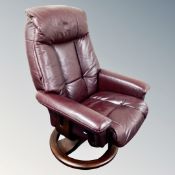 A Burgundy leather swivel reclining armchair