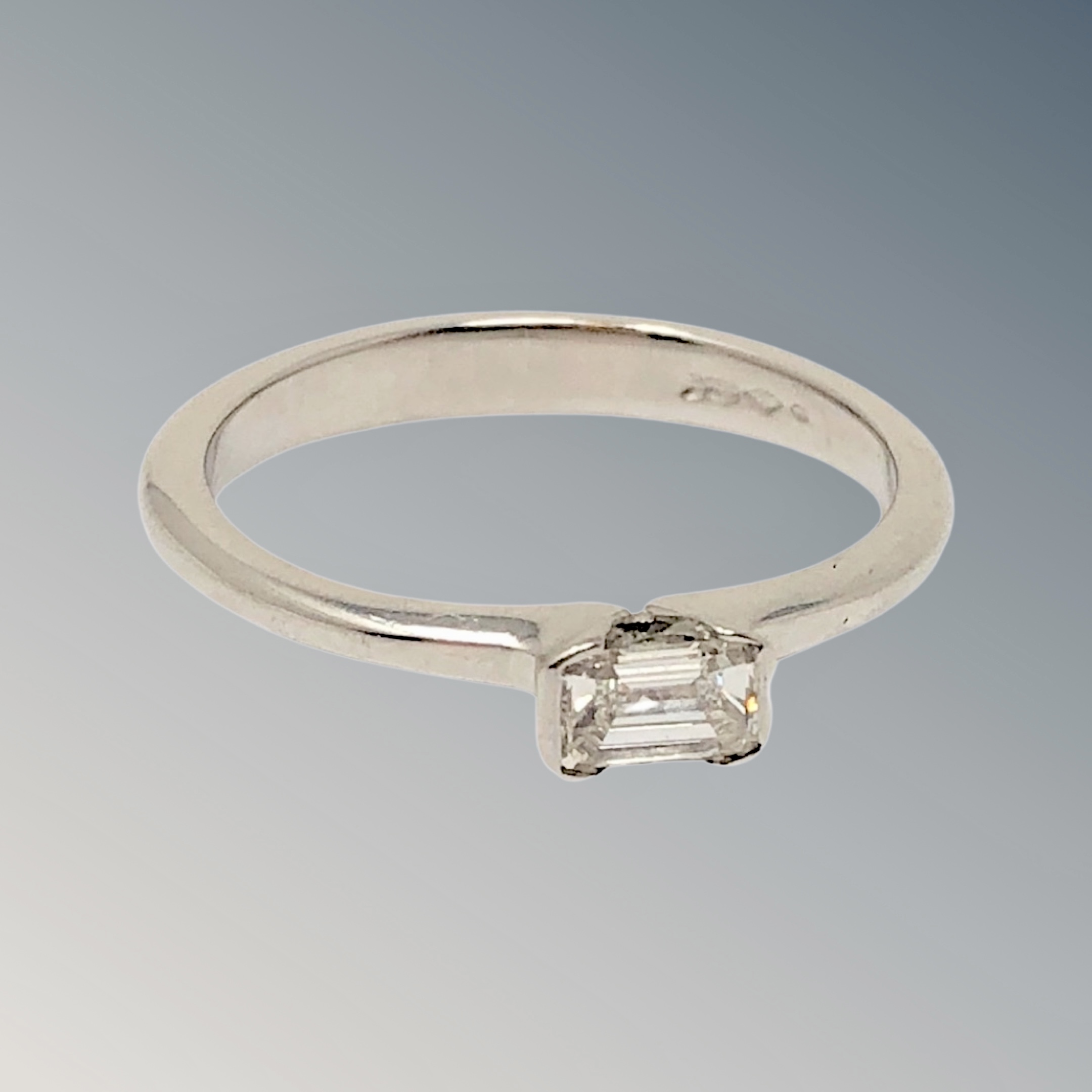 A platinum emerald cut solitaire diamond ring, approx. 0.