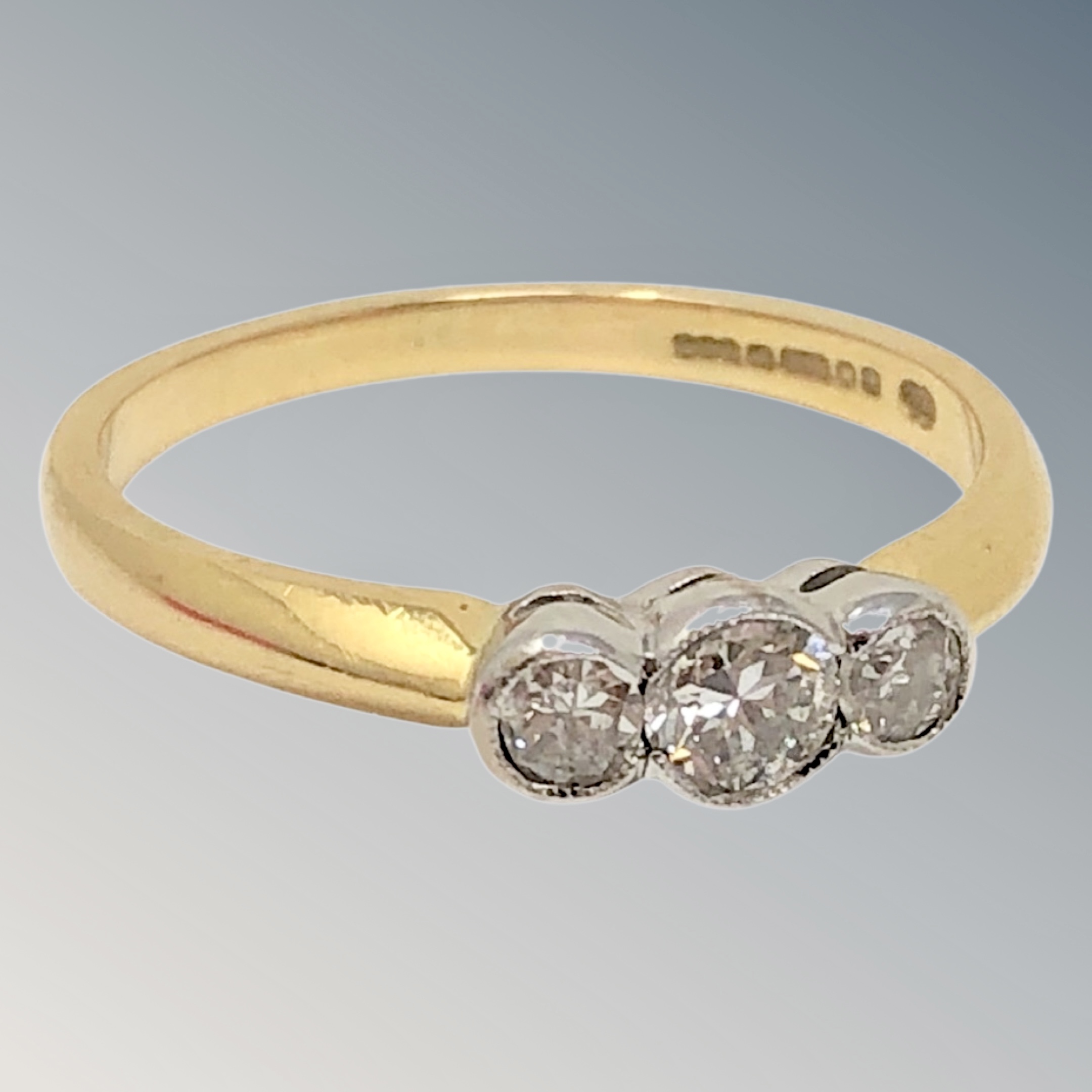 An 18ct gold three stone diamond ring, stated total diamond weight .