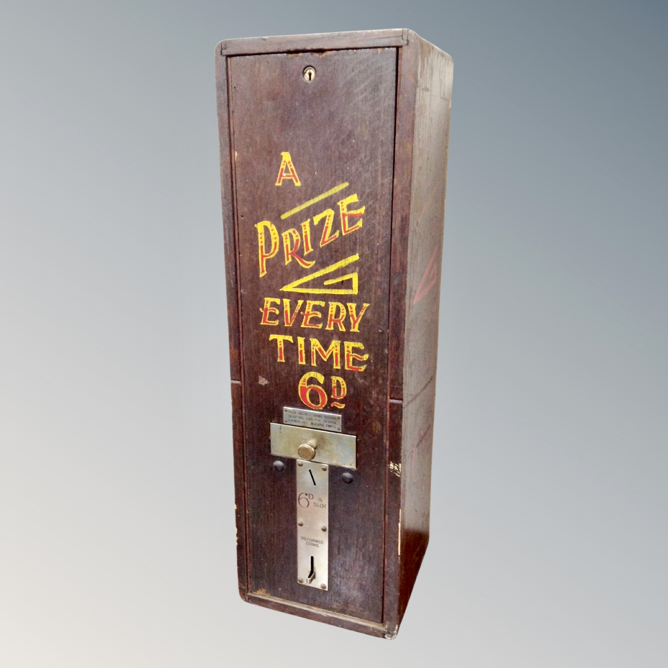 A 20th century oak cased cigarette machine with hand-painted decoration