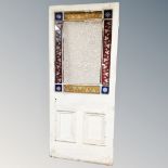 A late Victorian interior door with coloured glass panel inset, 203cm by 87cm.