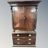An early 19th century mahogany double door linen press fitted with four trays on four drawer chest