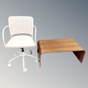 A white rattan swivel desk chair together with a bent plywood coffee table