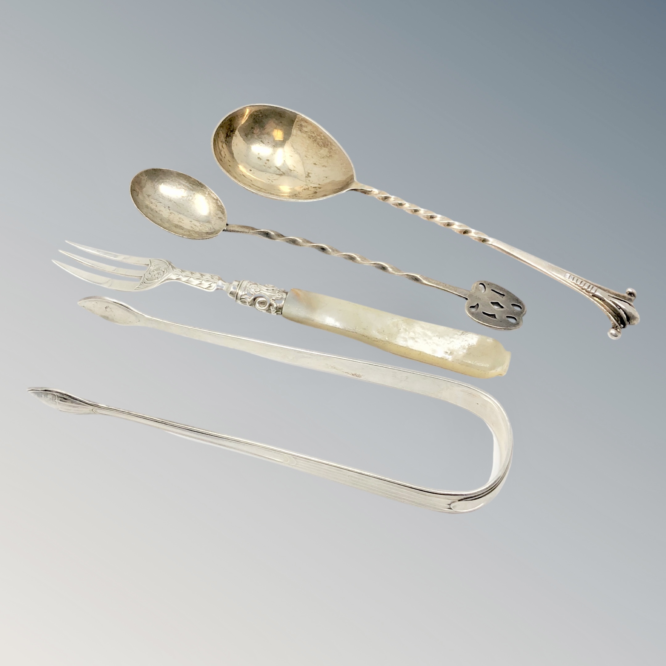 A group of silver cutlery including pair of Georgian tongs,