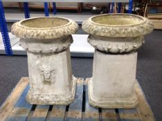 A pair of concrete planters on pedestals