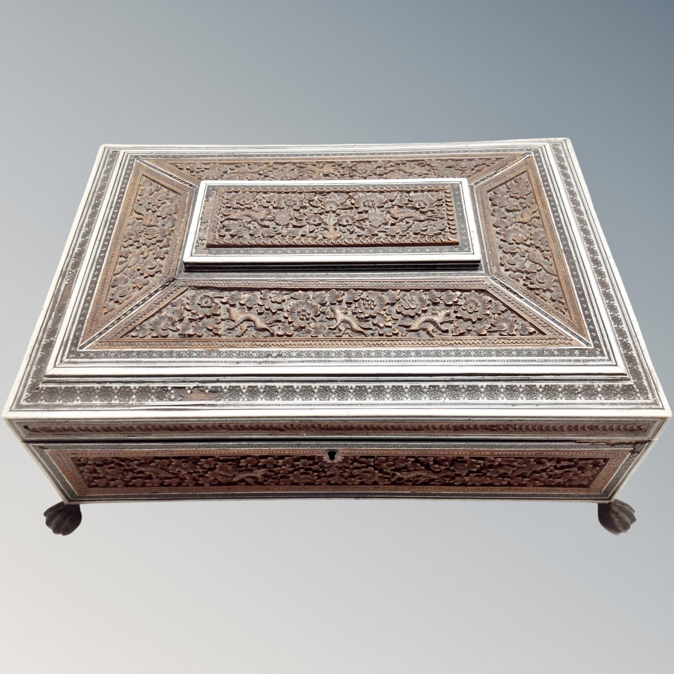 A 19th century Anglo-Indian Vizagapatam carved sandalwood and bone-inlaid work box on paw feet