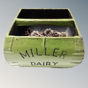 A Miller Dairy caddy containing pine cones