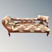 A late Victorian carved chaise longue in leaf pattern fabric
