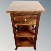 A contemporary square topped three tier side table