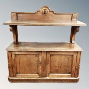 A late Victorian oak dumbwaiter fitted with cupboards beneath