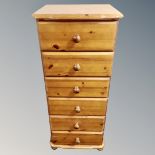 A narrow pine six drawer chest