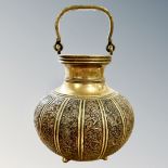 A 19th century Indian brass and copper swing-handled bulbous vessel, height 22cm including handle.