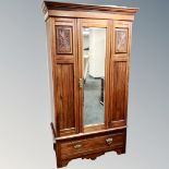 An Edwardian mahogany mirror door wardrobe fitted with a drawer