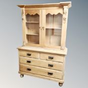 A Victorian pine double door glazed bookcase on four drawer chest
