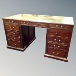 A 19th century twin pedestal desk fitted with eleven drawers with leather inset panel