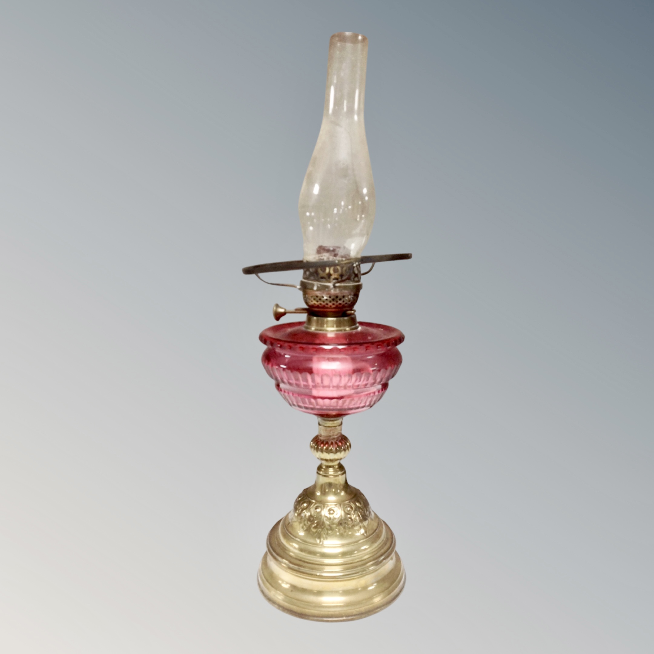 A Victorian brass oil lamp with cranberry glass reservoir together with three further oil lamps in - Image 2 of 2
