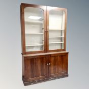 A Victorian mahogany double door glazed bookcase fitted with cupboards,
