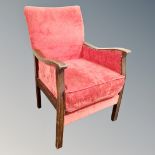 An early 20th century armchair in studded red fabric
