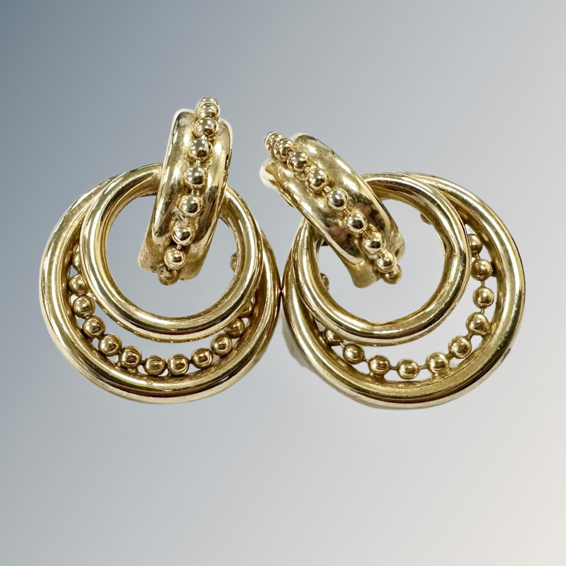 A pair of gold plated ornate earrings