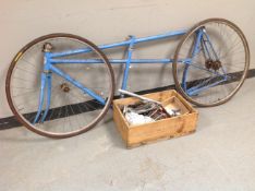 An FFCT tandem bike frame with wheels and box containing parts