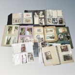 A box of six books and folders containing antique and later postcards,