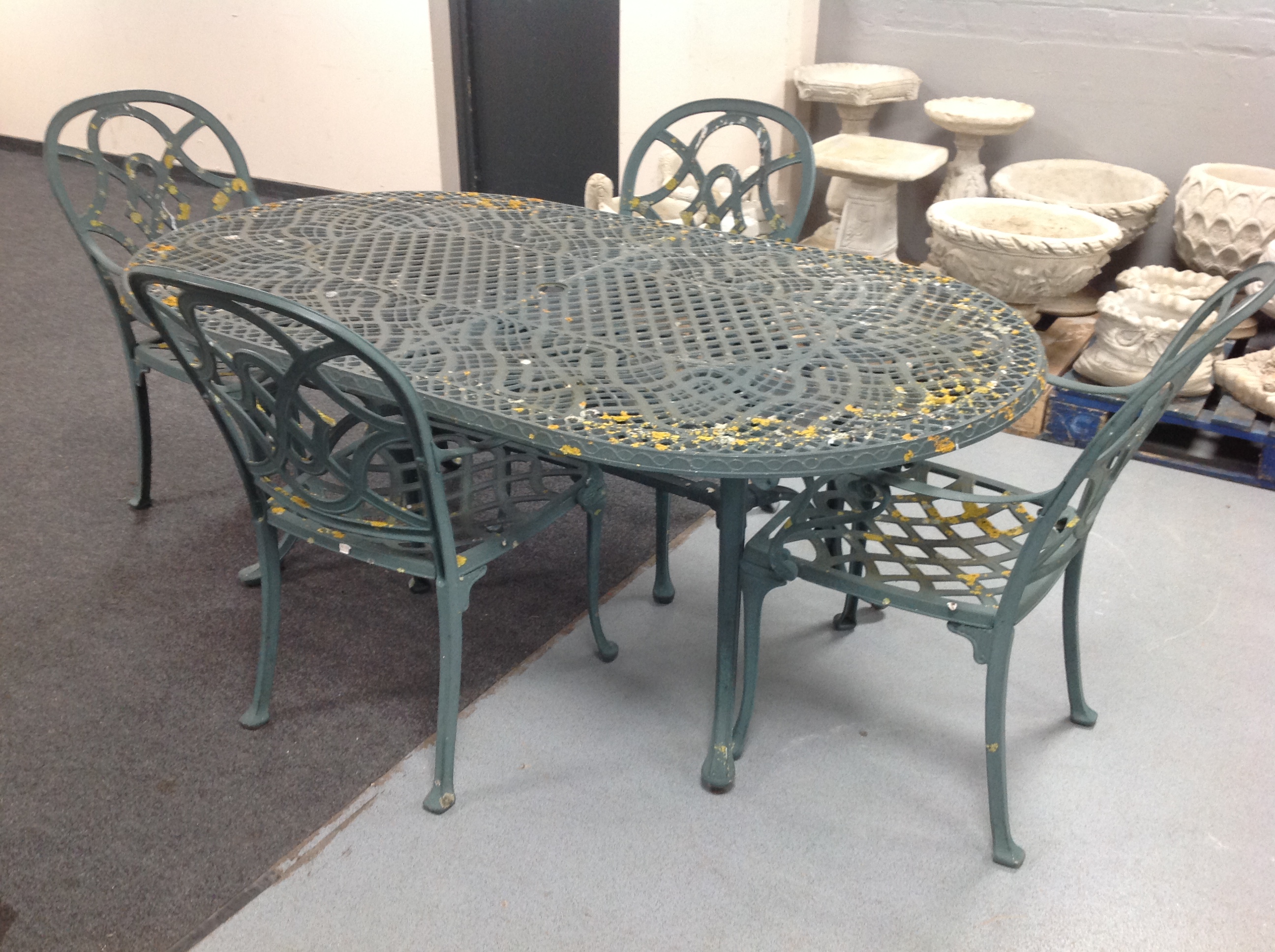 A wrought metal oval garden table together with six armchairs