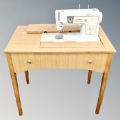 A Singer electric sewing machine in teak table