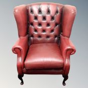 A Chesterfield wingback armchair in red leather
