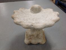 A concrete shell bird bath