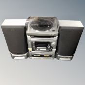 An Aiwa stereo system with speakers together with a box of vinyl records