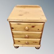 A three drawer pine bedside chest