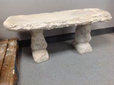 A concrete garden bench on squirrel pedestals