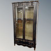 A French style ebonised double door vitrine fitted drawer beneath