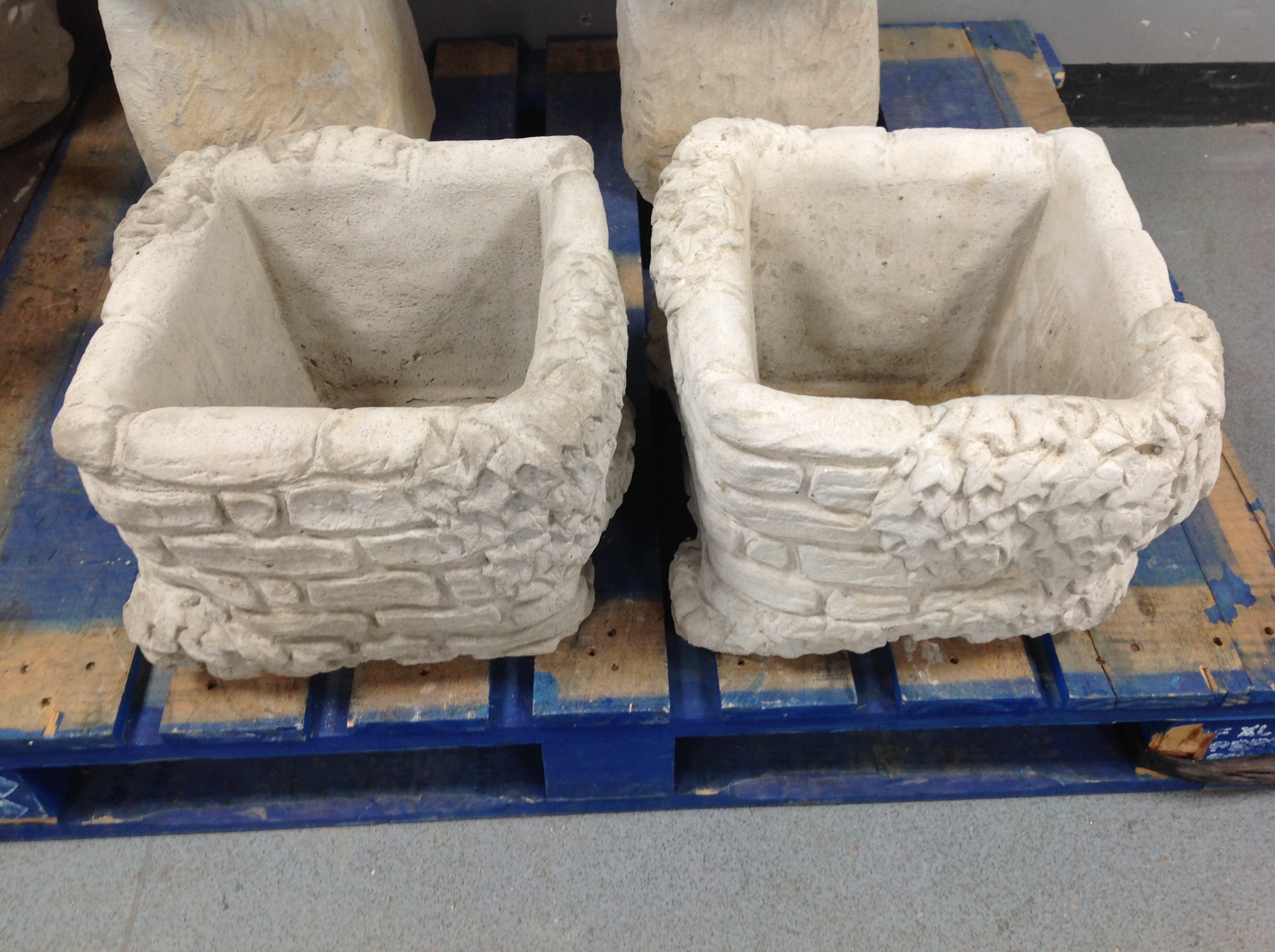 A pair of concrete brick and ivy planters