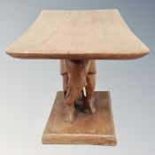 A hardwood occasional table on elephant pedestal