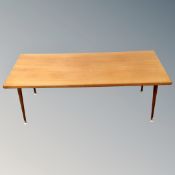 A mid century teak coffee table on raised legs