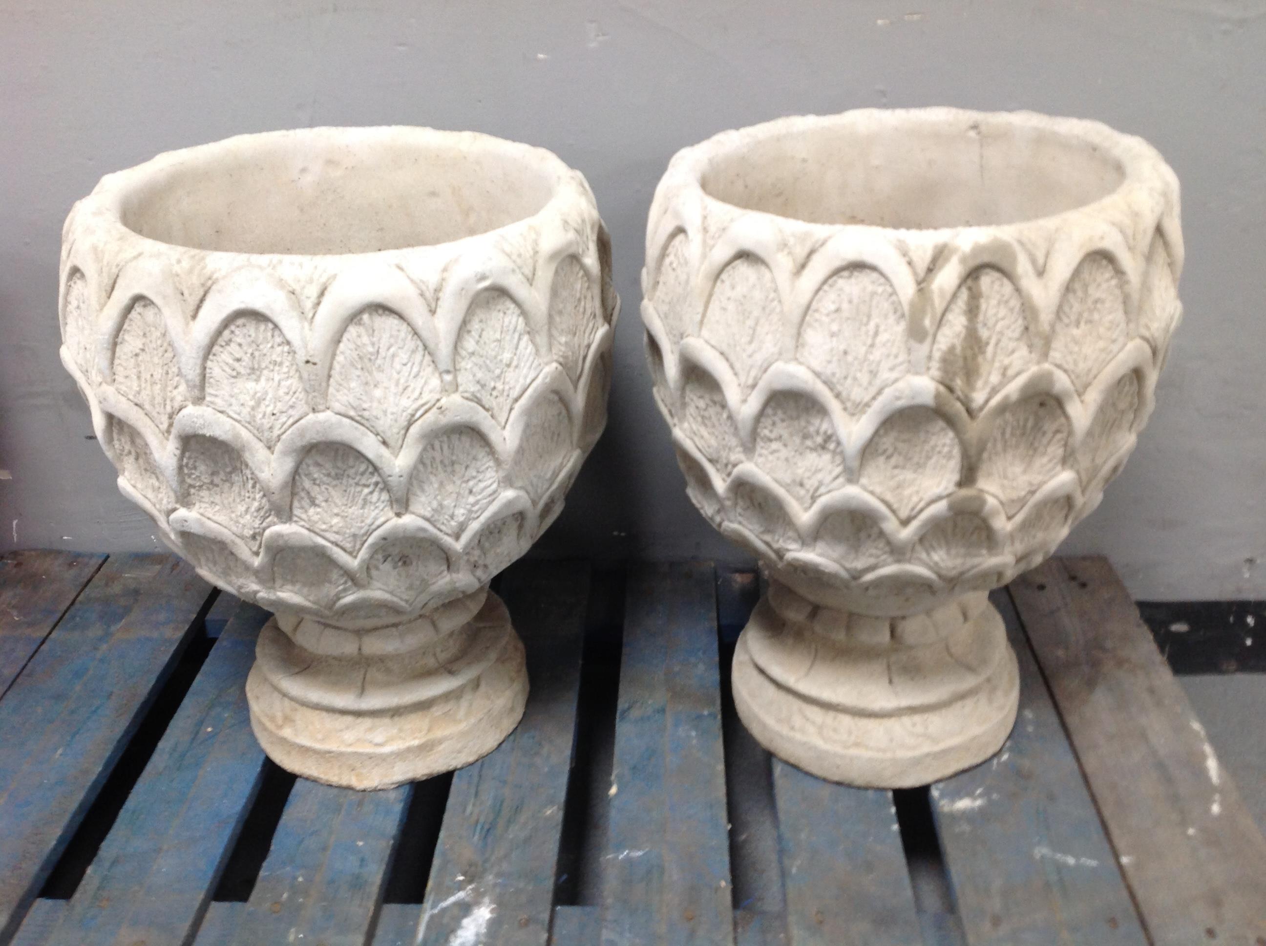 A pair of concrete pineapple urns on stands