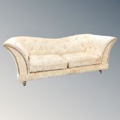 A contemporary buttoned two seater settee in golden fabric