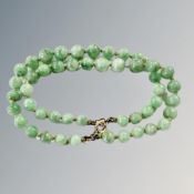 A double strand jade bracelet with gold clasp.