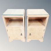 A pair of bleached walnut bedside cabinets with glass tops