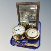 An antique brass embossed bevelled mirror together with a ship's clock and barometer,