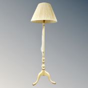 A painted standard lamp on tripod feet with shade