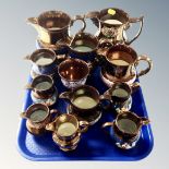 A tray of eleven antique copper lustre jugs together with copper lustre goblet (12)