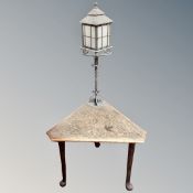 A carved poker work triangular table fitted with a lamp