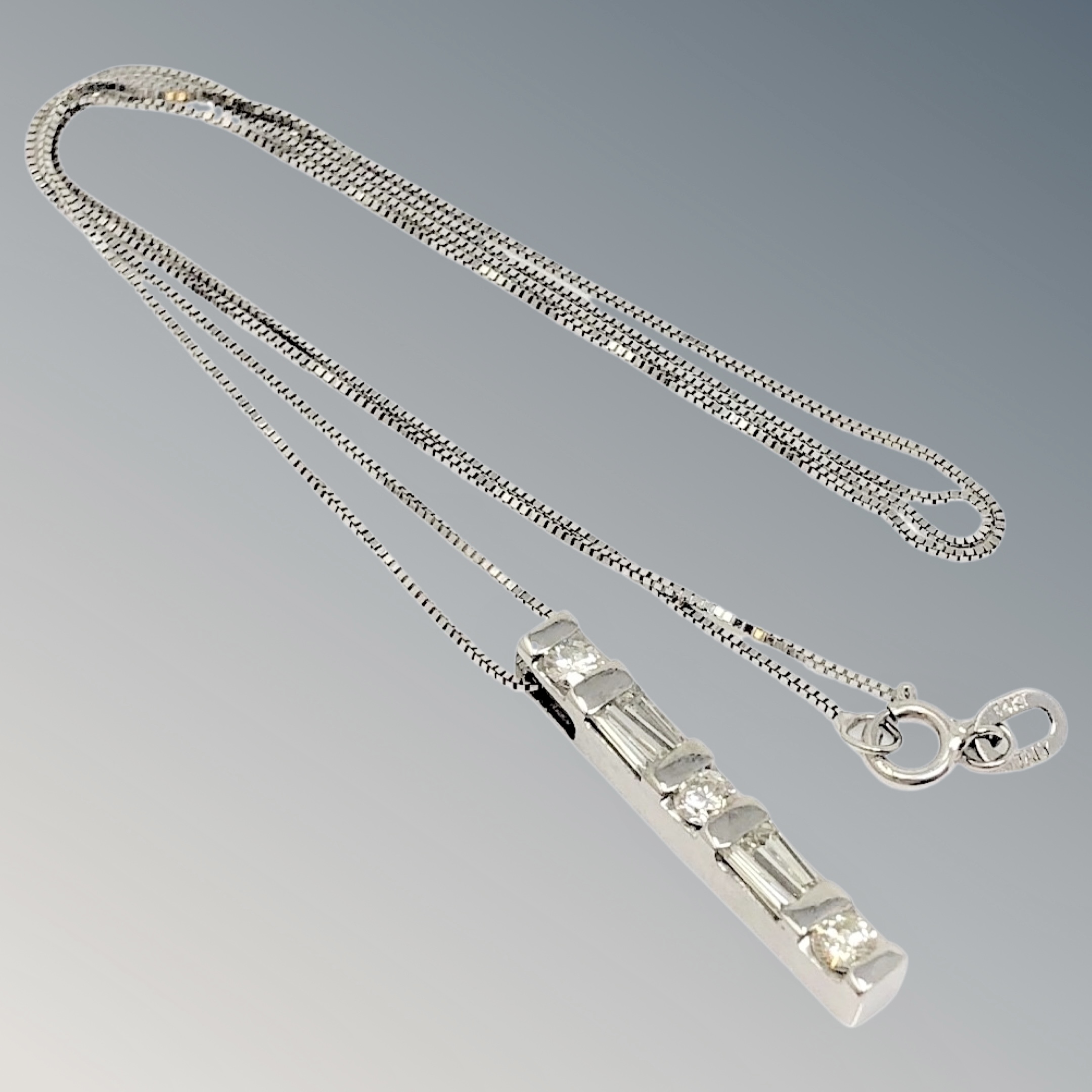 A 14ct white gold pendant and chain set with round and tapered diamonds, approx. 0.
