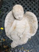 A concrete sleeping cherub ornament