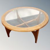 A 20th century circular teak G-Plan glass topped coffee table with under stretcher
