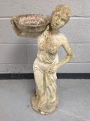 A concrete figure of a female with basket