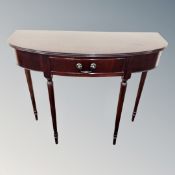 A Regency style inlaid mahogany D-shaped hall table on raised tapered legs