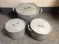 Three graduated aluminium catering cooking pots with lids